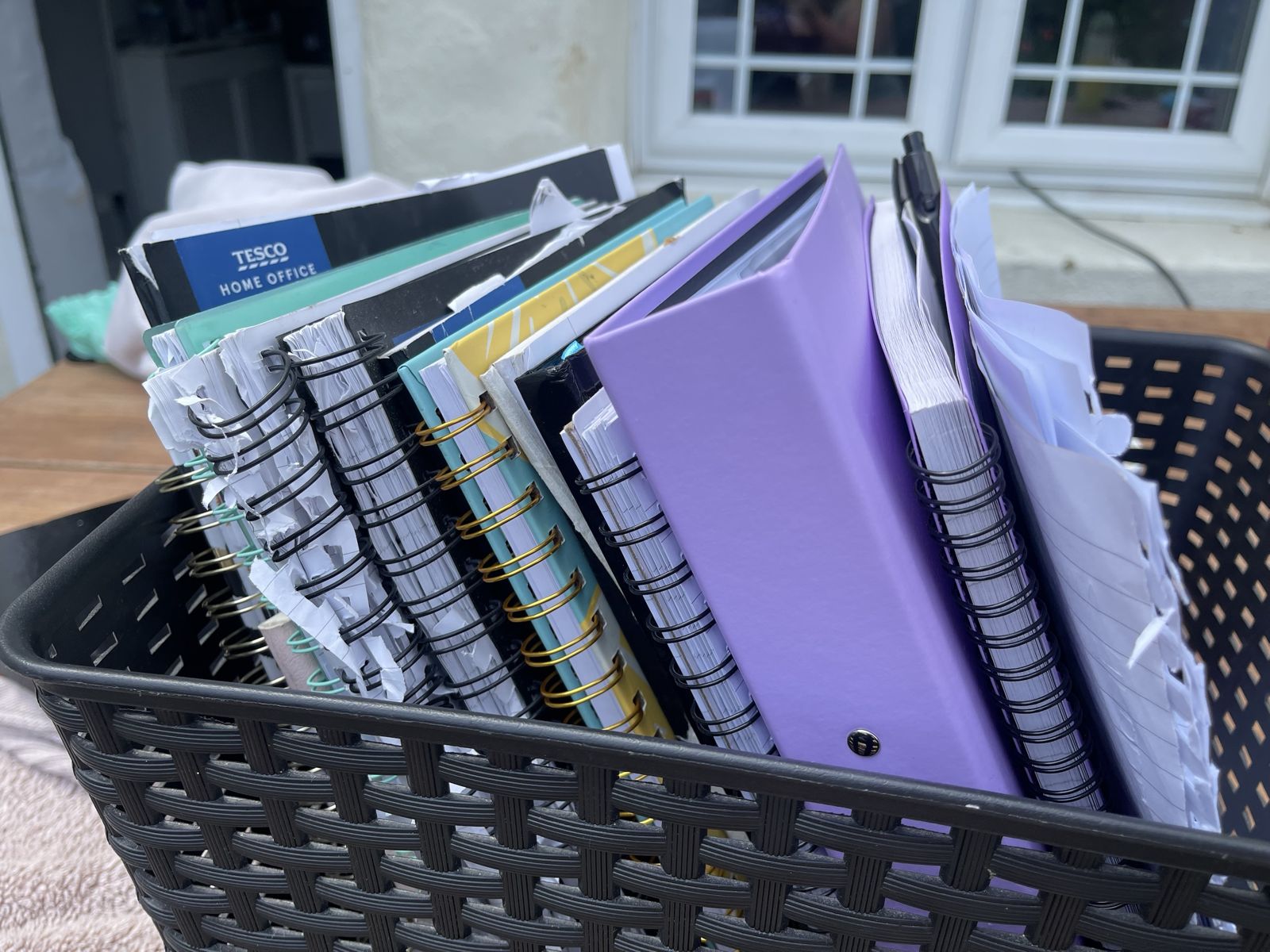 A basket full of worn business notebooks and planners